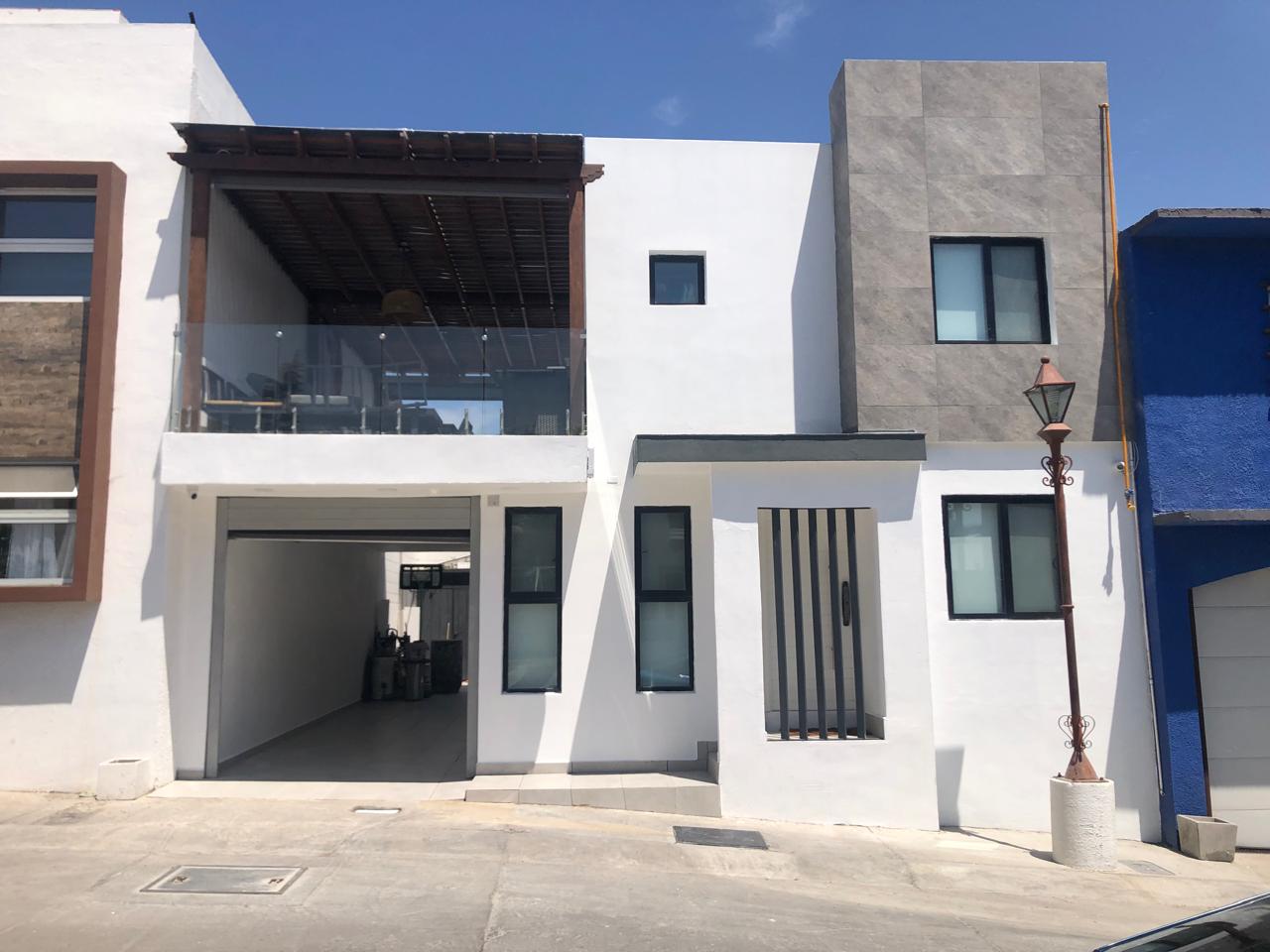 Fachada moderna de casa en blanco y negro diseñada con enfoque en arquitectura sustentable, eficiencia energética y funcionalidad.