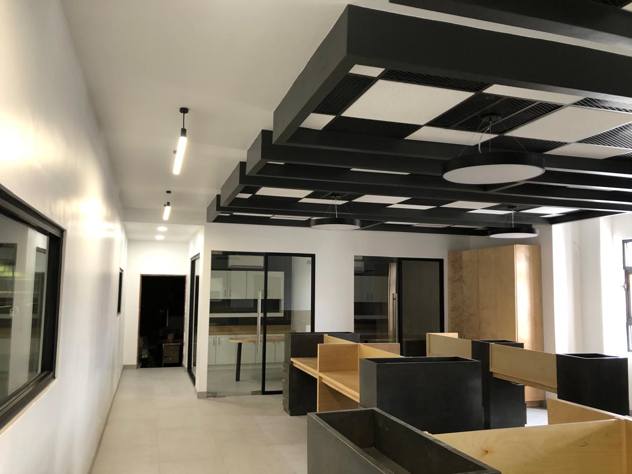 Oficina moderna remodelada de MAPA, con diseño de interiores en colores claros, detalles en metal negro y madera natural